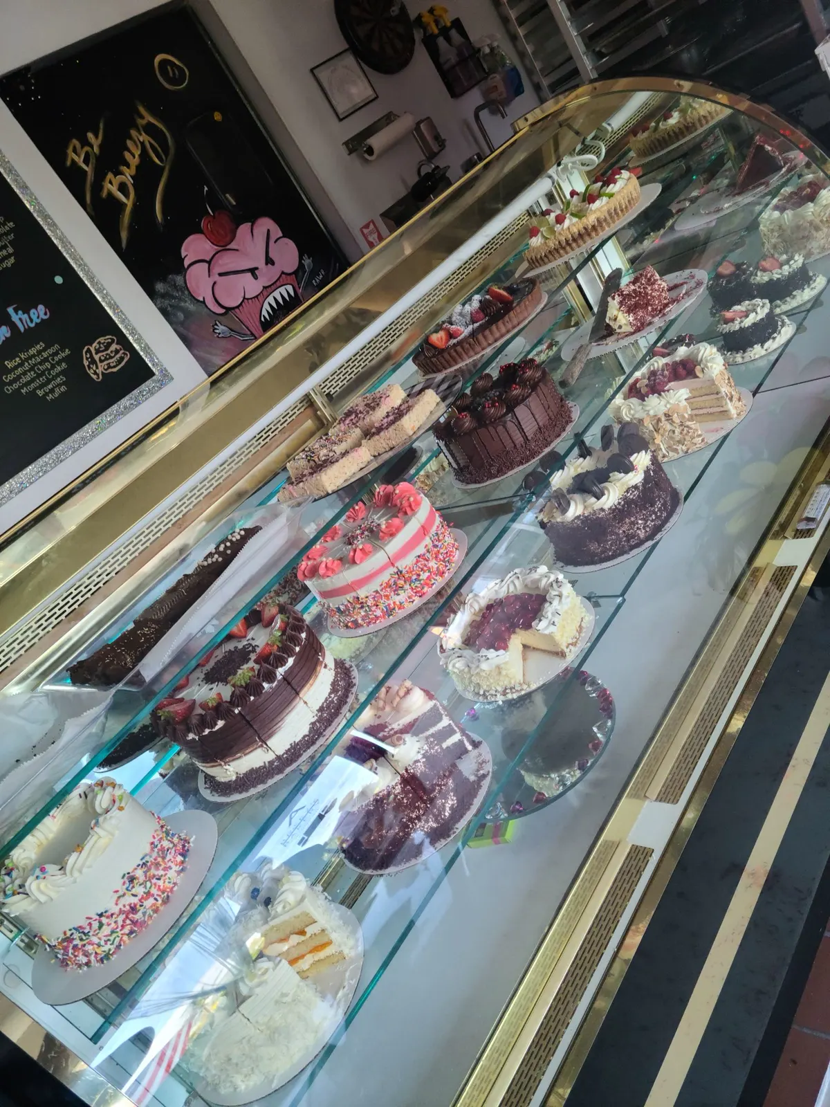 The bakery's glass case full of layer cakes and cheesecakes