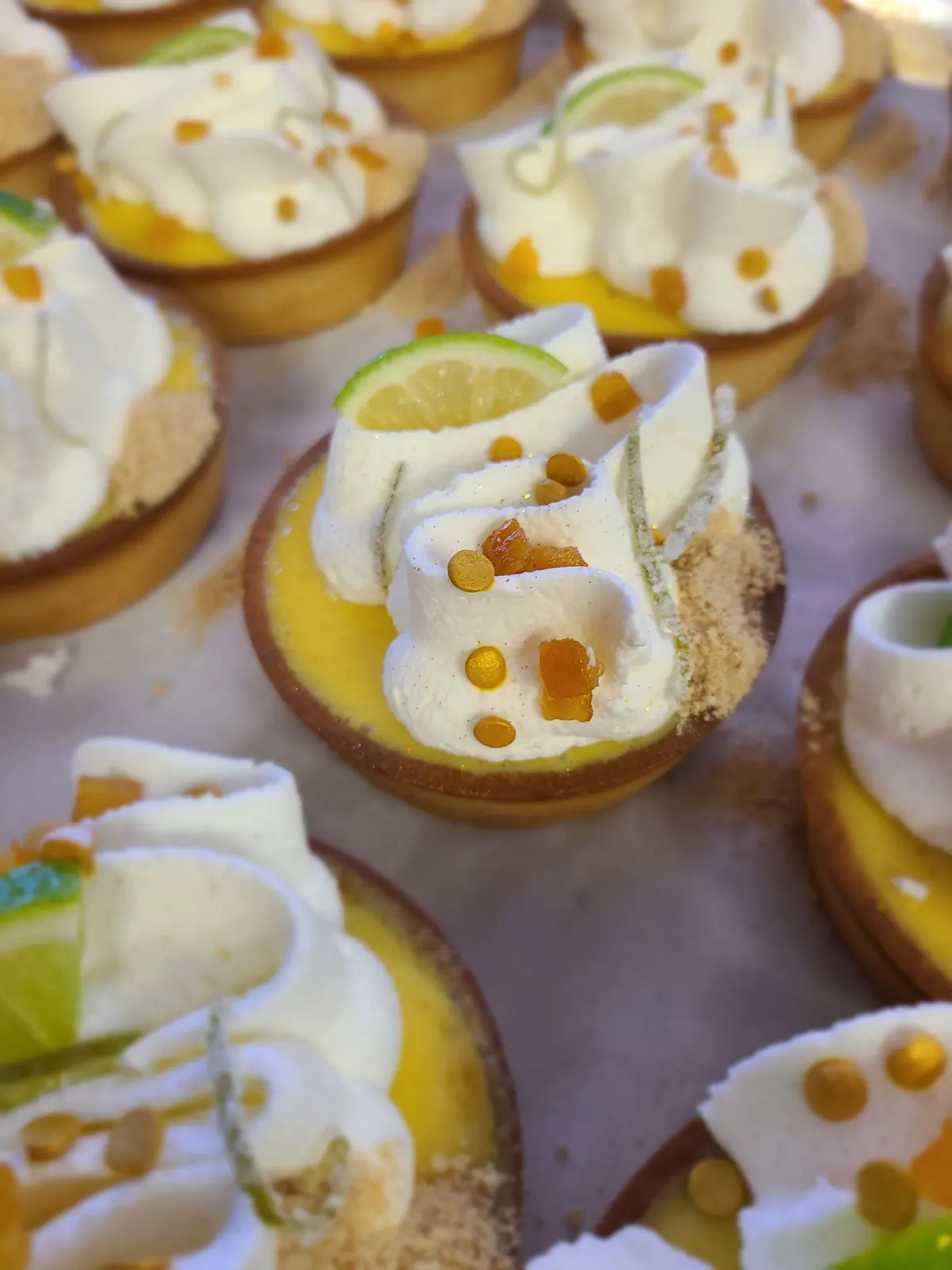 Key lime tarts with whipped cream and lime slices